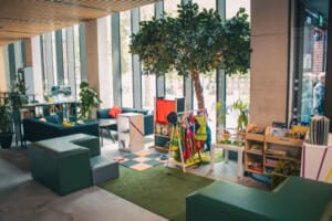 An indoor room contains a tree with bright decor and open storage areas.